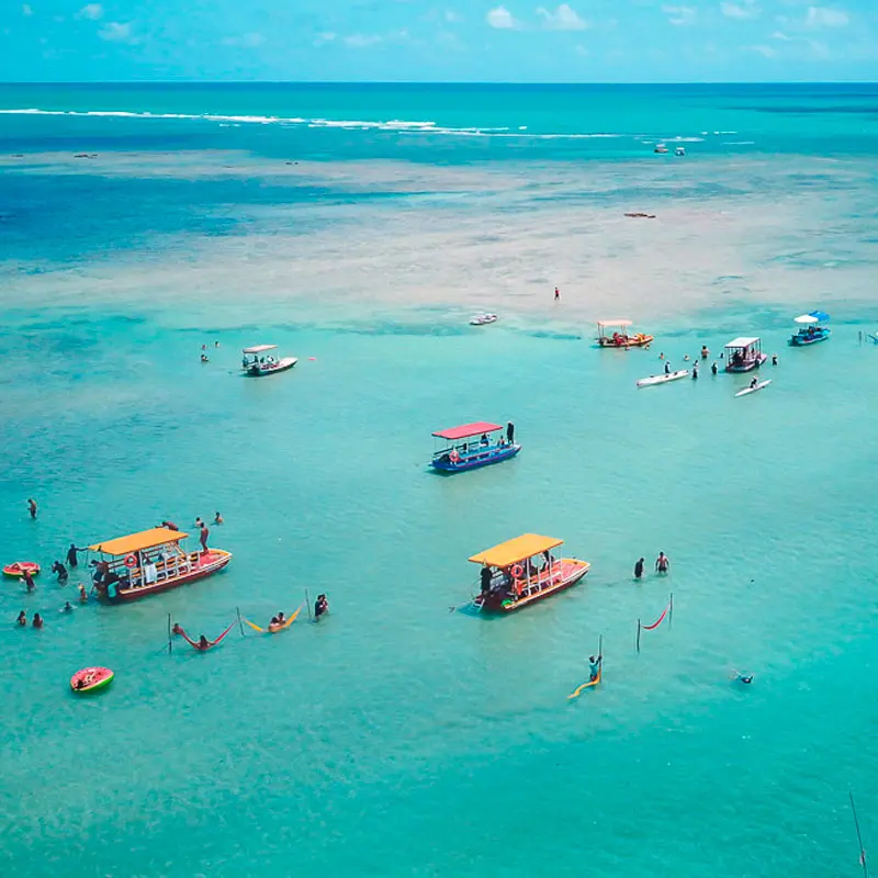Praia do Patacho com mar azul e coqueiros
